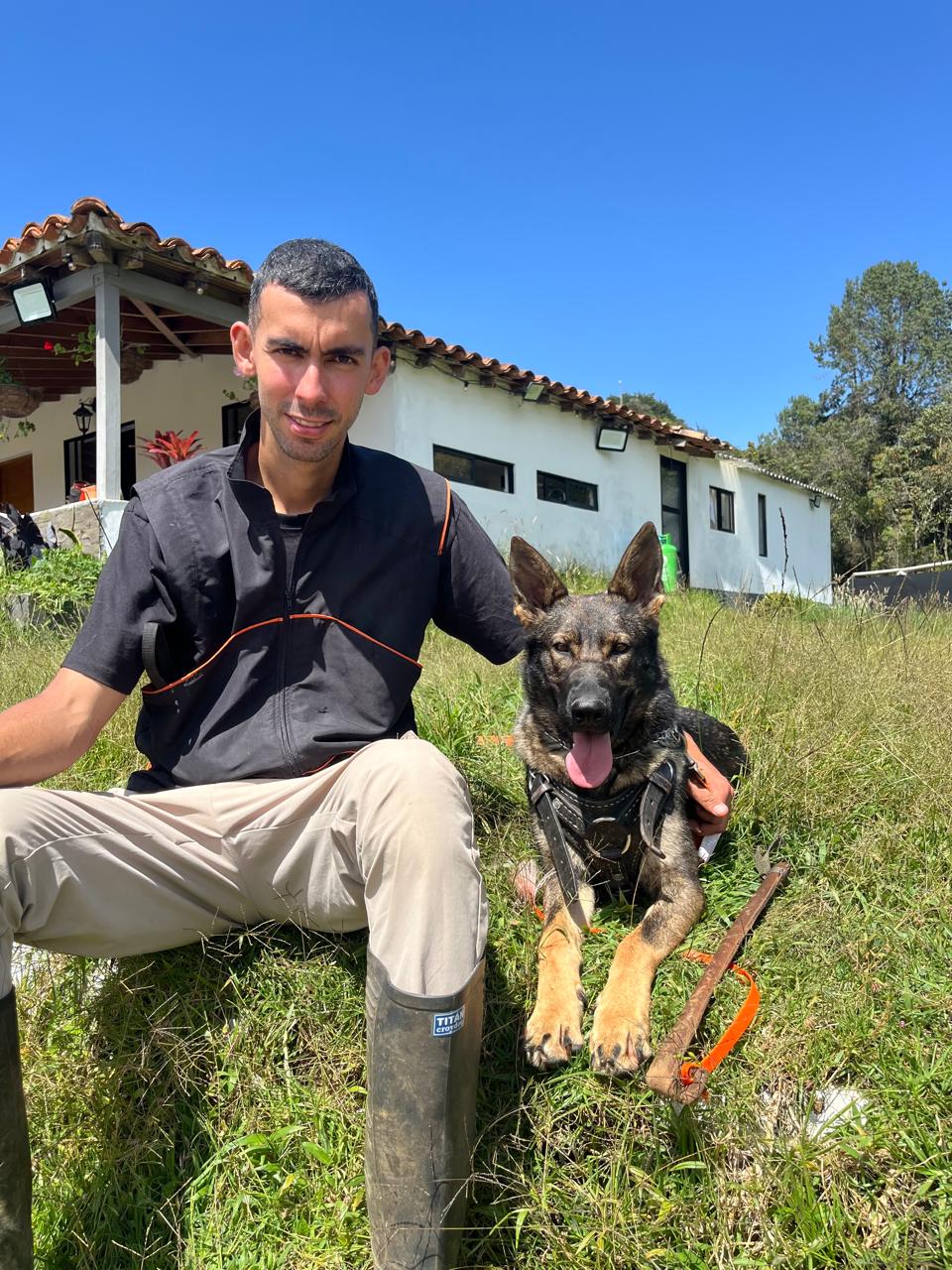 Felipe Ossa with German Shepherd on training field in Colombia